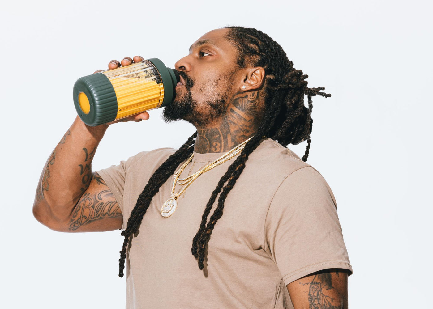 Marshawn Lynch (Beast Mode) drinking out of the Beast Mode blender accessory cup 	